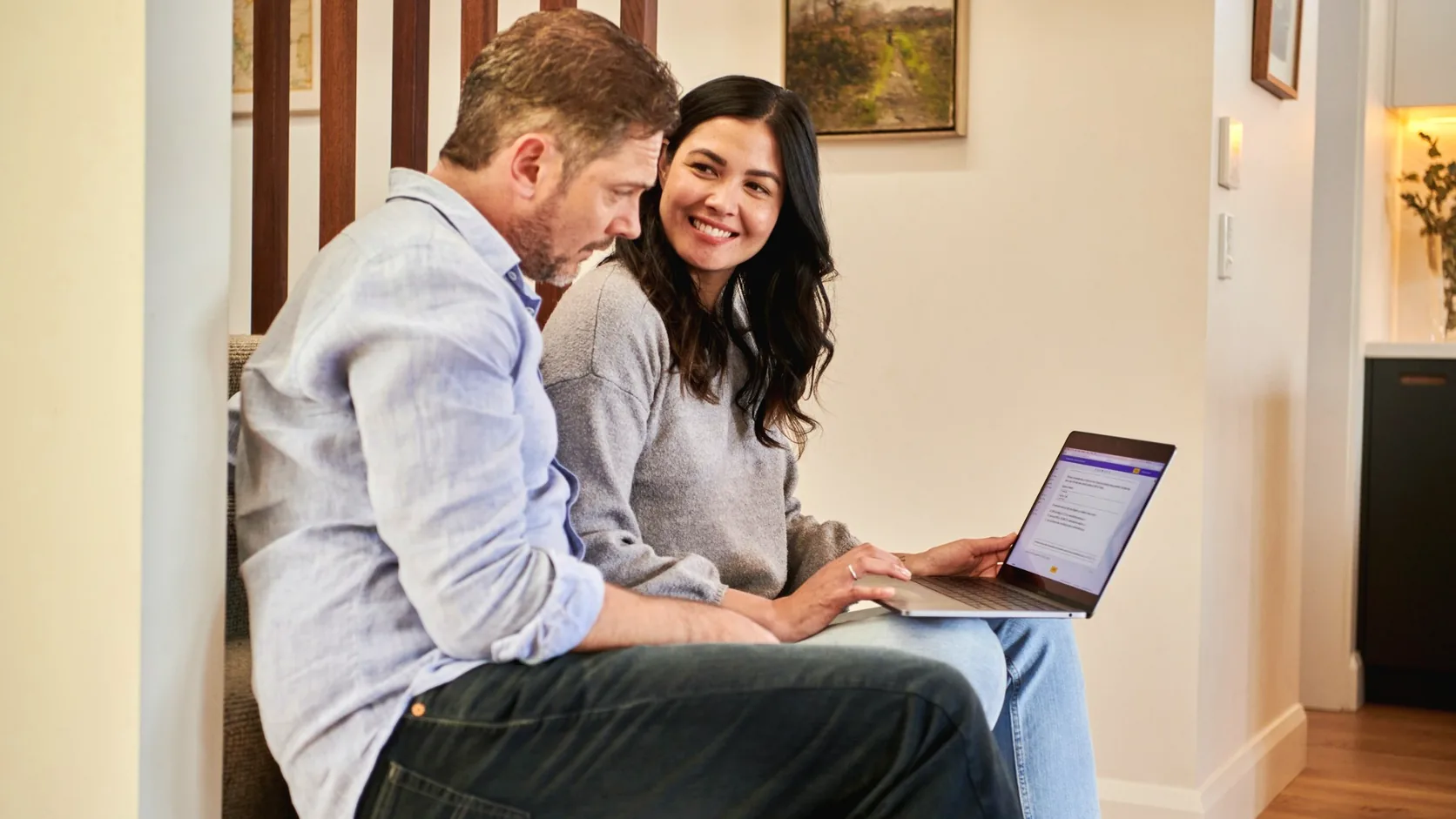 Couple reviewing household finances on a laptop as part of cashflow and wealth management planning.