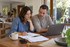 Couple in their 40s reviewing their household budget with a laptop and notebook at home.